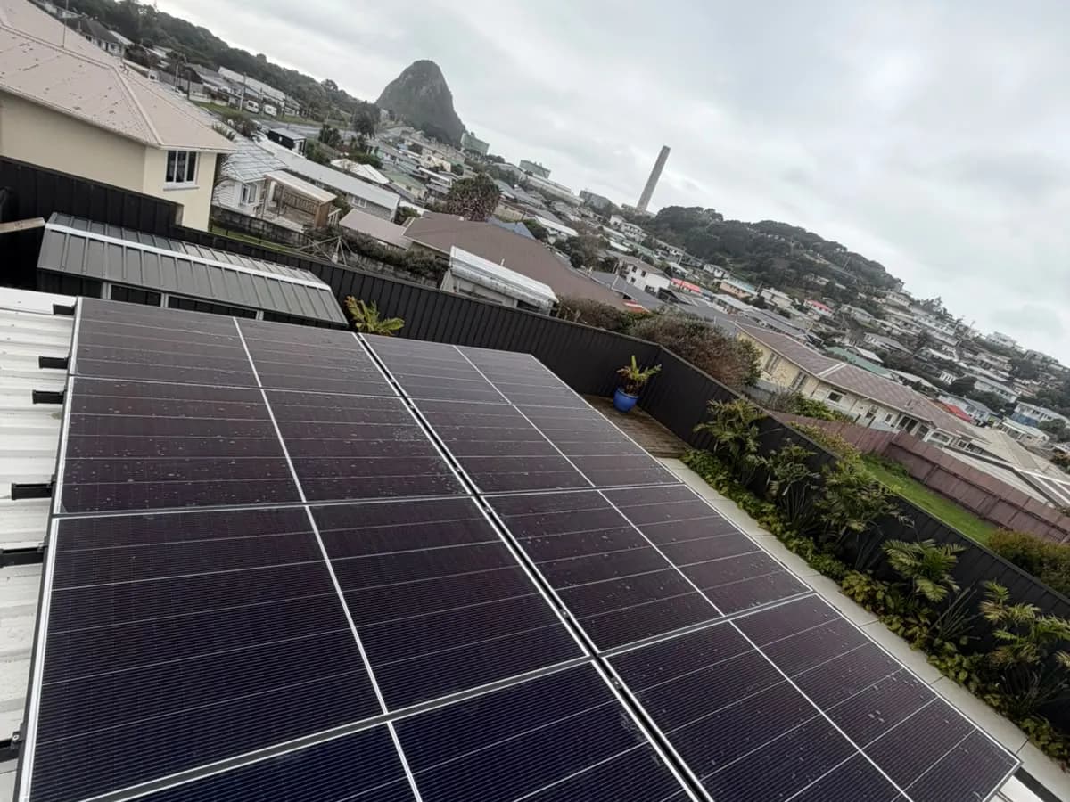 A 10.45kW EFS Solar array on a New Plymouth roof, Taranaki, with Paritutu Rock and the coast behind