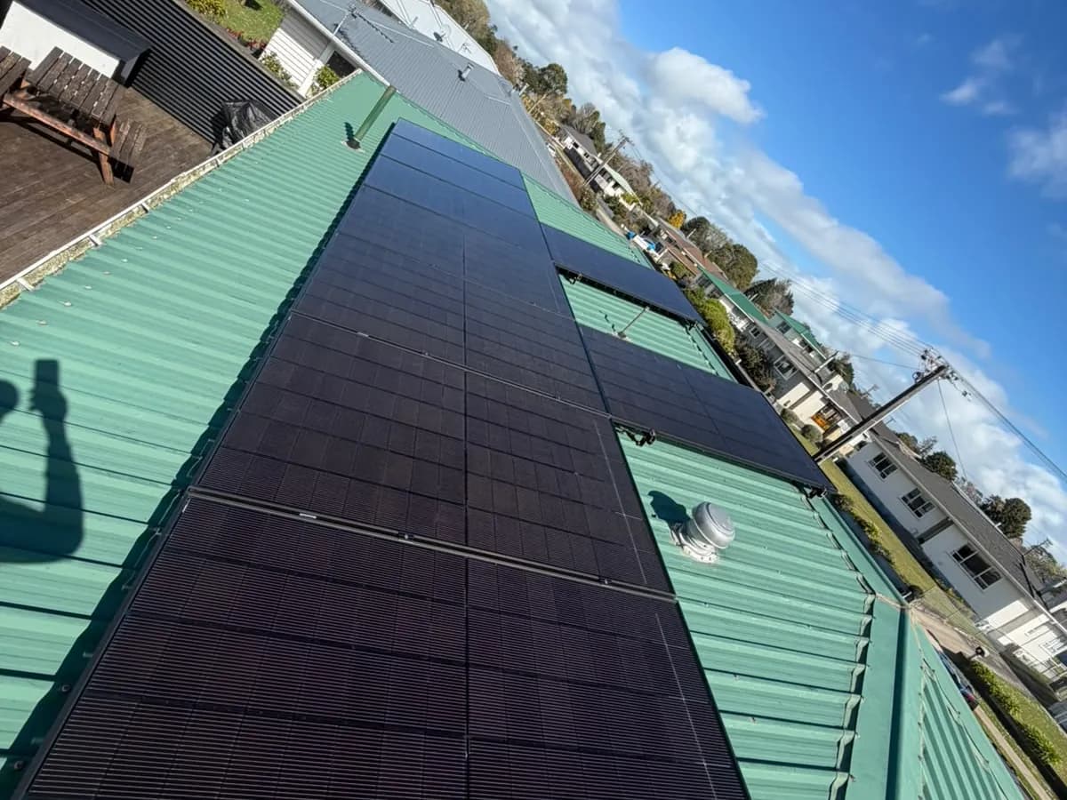 A 6.83kW EFS Solar array on a green metal roof in Stratford, Taranaki, on a hillside street
